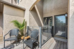 a balcony with two chairs and a table at 1935 Bohicket Marina in Seabrook Island