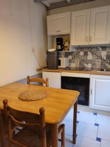 a kitchen with a wooden table in a kitchen at la petite maison in Granville