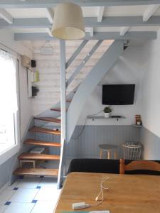 a staircase in a room with a table and a tv at la petite maison in Granville