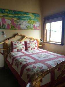 1 dormitorio con 1 cama con edredón en A Swan Nest Inn, en Seward