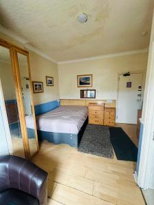 een slaapkamer met een bed en een bank erin bij Saxonia guest house in Weston-super-Mare