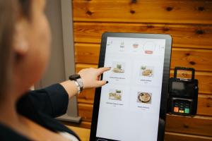 a woman is pointing at a menu on a ipad at Arden Parks Petite Suisse in Dochamps