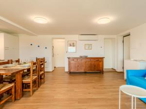 a dining room with a table and a blue couch at Apartment Persico by Interhome in Consiglio di Rumo