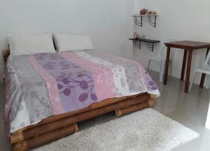 a bedroom with a bed with a blanket and a rug at Hangout Beach Resort in Caticlan