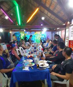 a group of people sitting at a long table at Hangout Beach Resort in Caticlan