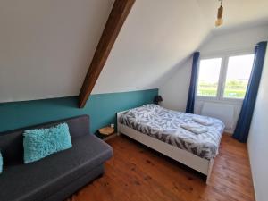 a small bedroom with a bed and a couch at Le Terracotta, Proche plage in Oye-Plage