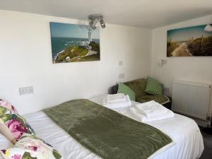 Un dormitorio con dos camas y una silla y un faro. en Cosy Cabin for Two with Lovely Countryside Views, Near Kingsbridge, en Churchstow