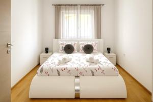 ein Schlafzimmer mit einem weißen Bett mit zwei Teddybären darauf in der Unterkunft Holiday Home Nido Verde in Santalezi