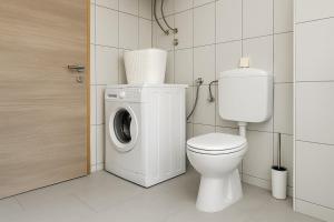 ein Badezimmer mit Waschmaschine und Toilette in der Unterkunft Holiday Home Nido Verde in Santalezi + 3 Fotos