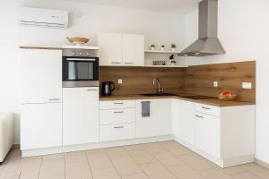 eine weiße Küche mit weißen Schränken und einer Spüle in der Unterkunft Holiday Home Nido Verde in Santalezi