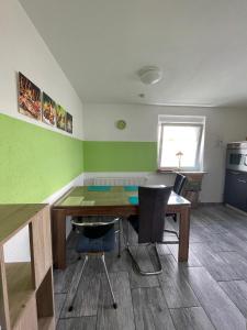a kitchen with a wooden table and chairs in a room at Ferienwohnung Bailey in Laupheim