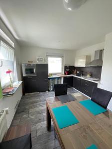 a kitchen with a wooden table and blue mats at Ferienwohnung Bailey in Laupheim +42 photos