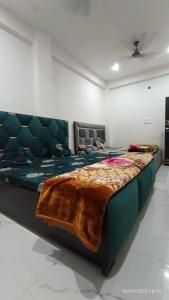 a bedroom with a large bed with a blanket on it at Nana ji Rest house in Vrindāvan