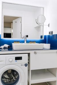 a white bathroom with a washing machine and a sink at Blue Side Orbi City in Batumi