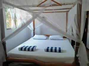 a bed with two pillows on it in a room at The Village Tangalle in Tangalle