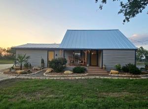 a house with a metal roof and a porch at Historic Farmhouse - Tranquil Nature Escape in Hondo