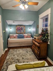 a living room with a couch and a ceiling fan at Historic Farmhouse - Tranquil Nature Escape in Hondo