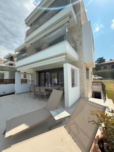 a modern house with a patio with a table and chairs at Zennova #65 Villa Vanina in Nikiti