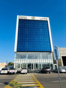 a large building with cars parked in front of it at شقق كلاس للشقق المخدومة اقتصادي in Hail