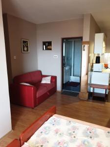a living room with a red couch and a table at Apartmani Štulec in Preko