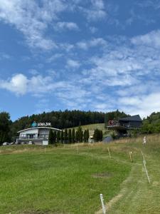 a large grass field with a building in the background at Apartament Odlot in Międzybrodzie Żywieckie