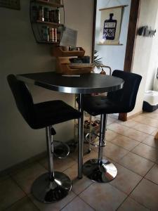 a black table with two black chairs in a room at Chambres à St Loup-Marseille in Marseille