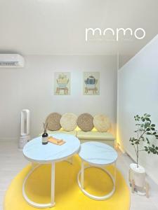 a table and two stools in a room at Pomomo House in Daegu