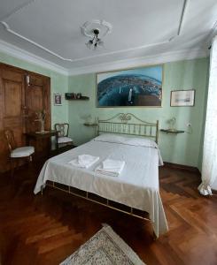 a bedroom with a bed with white sheets and a painting on the wall at Affittacamere Rilke in Trieste