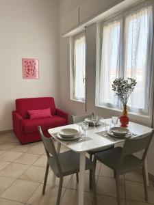 a living room with a table and a red couch at Ponente Blue Appartamenti, 1 in Arma di Taggia