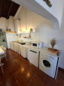 a kitchen with a washer and dryer in a room at Title e Title - Alentejo in Monforte