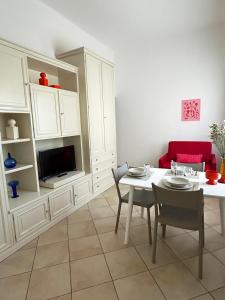 a living room with a table and a tv at Ponente Blue Appartamenti, 1 in Arma di Taggia +8 photos