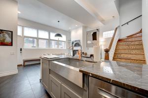 a large kitchen with a sink and a staircase at Large Condo with Outdoor Deck in Historic Chicago District home in Chicago
