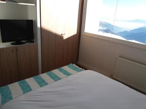 1 dormitorio con 1 cama, ventana y TV en Apartamento El Colorado en El Colorado