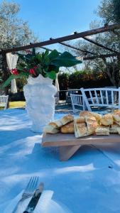 a table with a plate of bread and a white vase at Amati home in Floridia