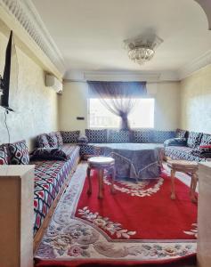 uma sala de estar com um sofá e uma mesa em logement exceptionnel réservé aux familles em Meknès