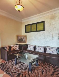uma sala de estar com um sofá e uma mesa em logement exceptionnel réservé aux familles em Meknès