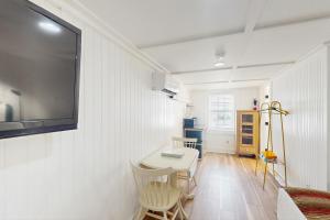 タイビーアイランドにあるGeorgianne Suite Fiveのテーブルと壁にテレビが掛かっている部屋