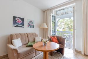 una sala de estar con un sofá y una mesa en Ferienwohnung 8 Aparthotel Binz, en Binz