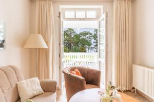 Una sala de estar con una silla y una mesa. en Ferienwohnung 8 Aparthotel Binz, en Binz 6 fotos más