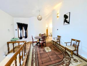 a living room with a table and chairs at 5 Bedroom Villa-Teak Tales managed by Futurve in Kodaikānāl