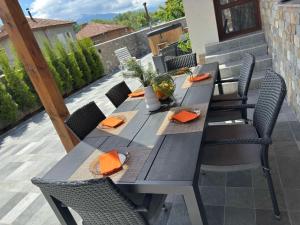 a wooden table and chairs on a patio at Вила Рафаела-Мартина in Dobrinishte +10 photos