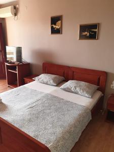 a bedroom with two beds and a television in it at Apartmani Štulec in Preko