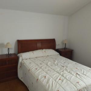 a bedroom with a bed with two nightstands and two lamps at Casa en Loira Marín in Marín