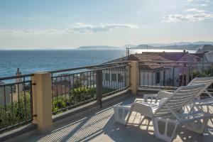een balkon met stoelen en uitzicht op de oceaan bij Apartments Max&Leon in Podstrana
