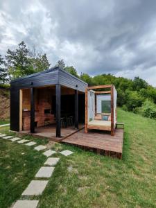 a black tent with a wooden deck in a field at Elysium Cabin in Muntele Rece