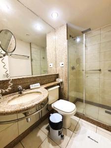 Un baño con inodoro, lavabo y ducha. en Apartamento com Estrutura de Hotel na Barra, en Río de Janeiro