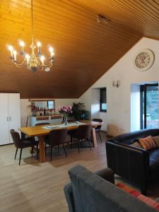 una sala da pranzo con un tavolo e un lampadario di CASA do AÇÔR ad Aldeia das Dez