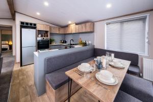 a kitchen and dining room with a table and chairs at Hot Tub Lodge, Victory Liberte 104 in St. Andrews +11 photos