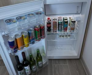an open refrigerator filled with bottles and drinks at Green House - Apartment with Separate Room and Sea View in Batumi