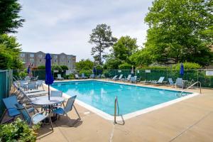 a swimming pool with chairs and a table and a table and chairs at about 1 Block to Bethany Beach, Retreat with Pool Access in Bethany Beach